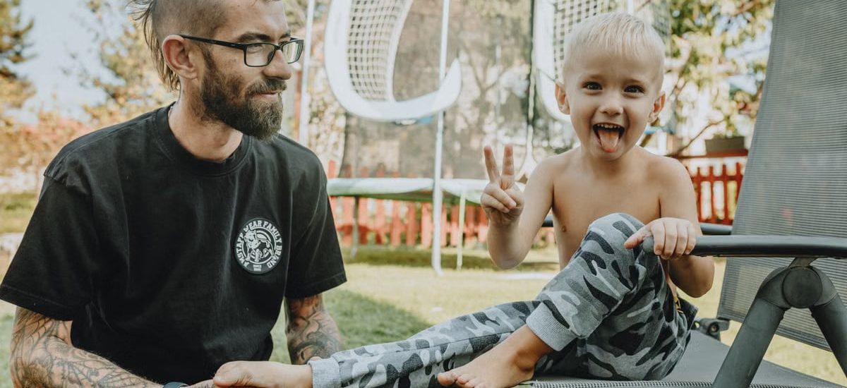 A joyful father and son bonding in a sunny backyard setting. Perfect for family and lifestyle themes.