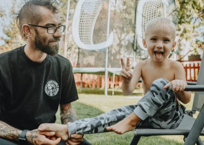 A joyful father and son bonding in a sunny backyard setting. Perfect for family and lifestyle themes.